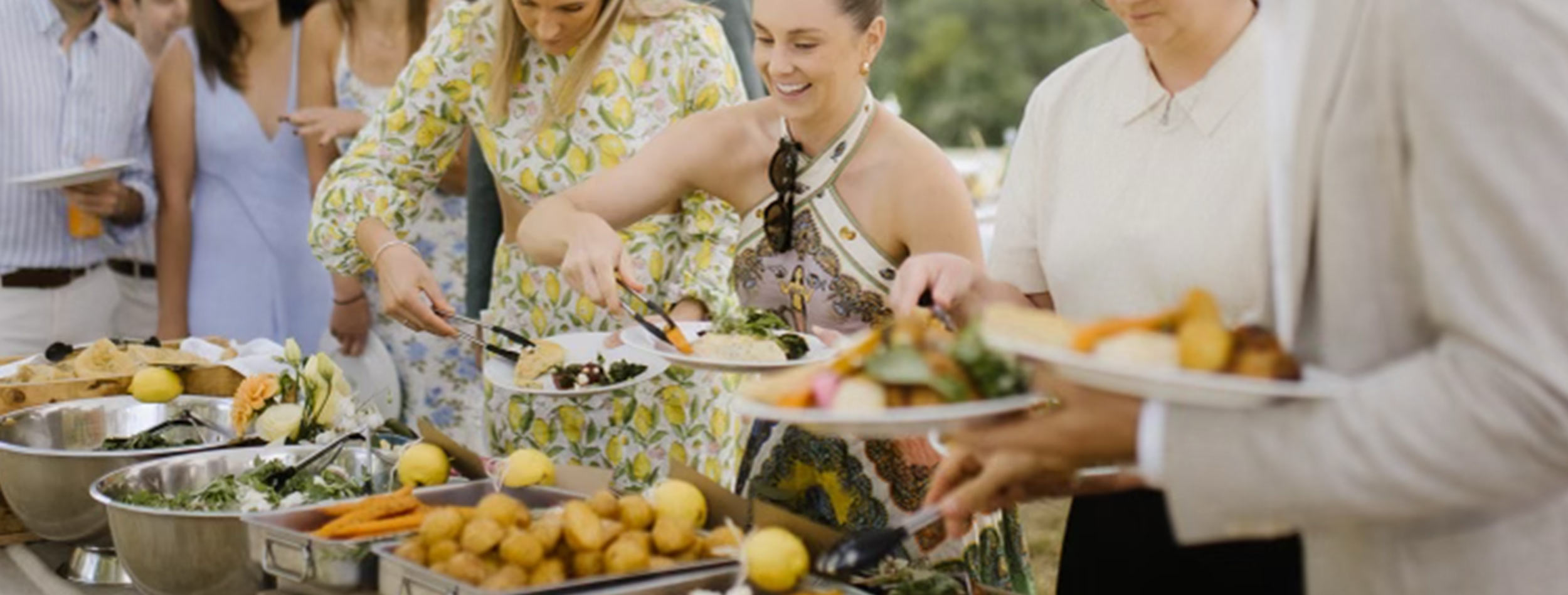 Wedding guests look very happy as they help themselves the food from the buffet table