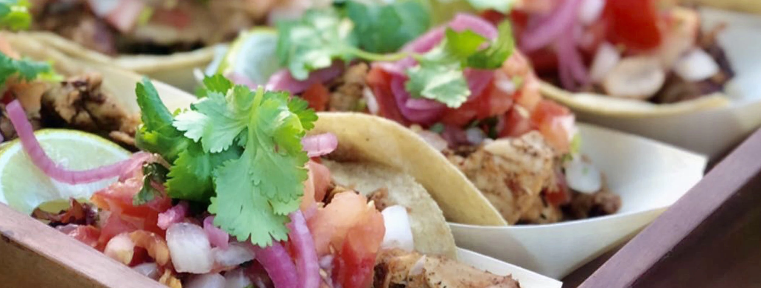 A close up photo of our Chicken Taco's, on a platter being served at a party