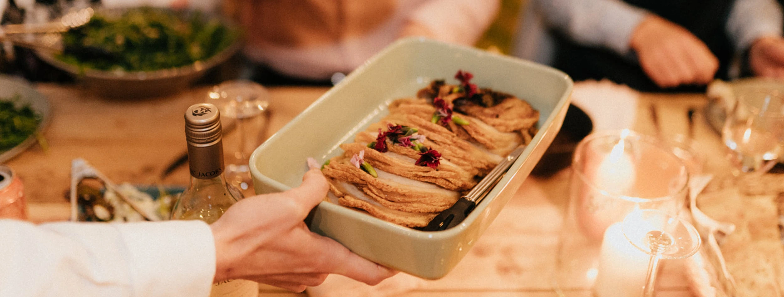 Wedding guests look on with anticipation, as Rolled pork belly porchetta is served to the table by our wait staff